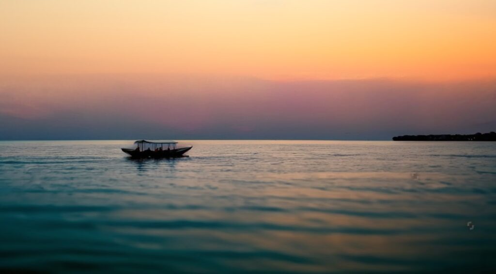 stock-photo-lake-kivu-rwanda-a-ferry-boat-sailing-in-the-water-sunset-at-sea-popular-tourist-spot-in-1306802401~2